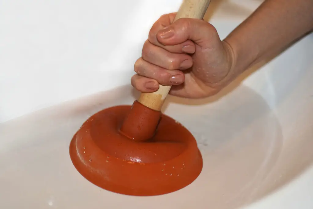 Plunger fixing a clog in the bath tub
